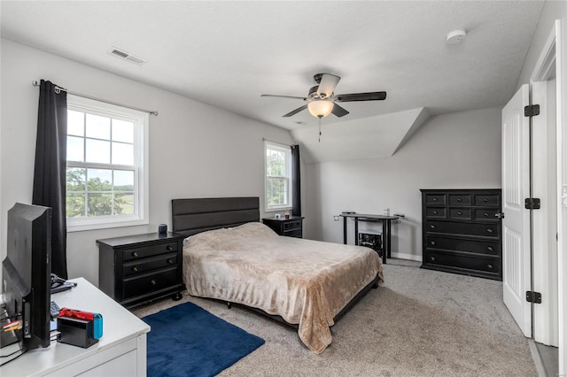 bedroom with a textured ceiling, ceiling fan, light colored carpet, and lofted ceiling