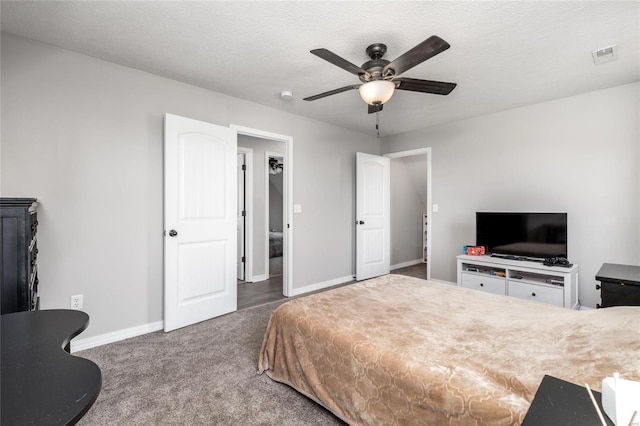 carpeted bedroom featuring ceiling fan and a textured ceiling