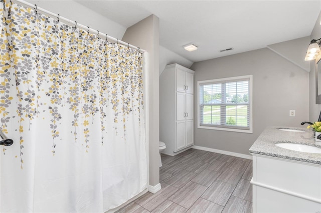 bathroom featuring dual vanity, toilet, and tile patterned floors