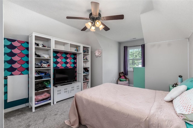 carpeted bedroom with ceiling fan, vaulted ceiling, and a textured ceiling