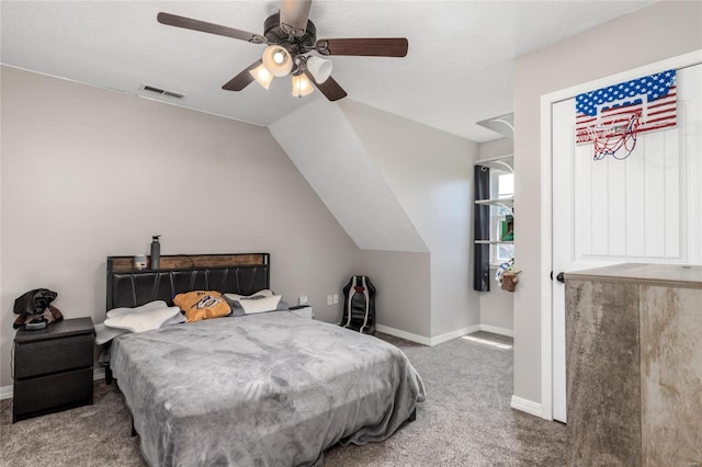 carpeted bedroom with ceiling fan and vaulted ceiling