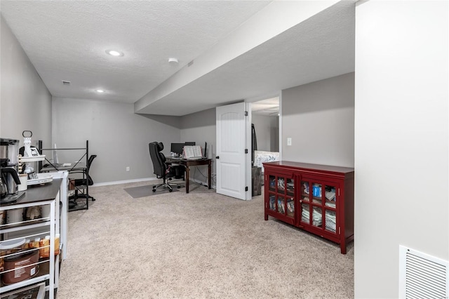 carpeted home office with a textured ceiling