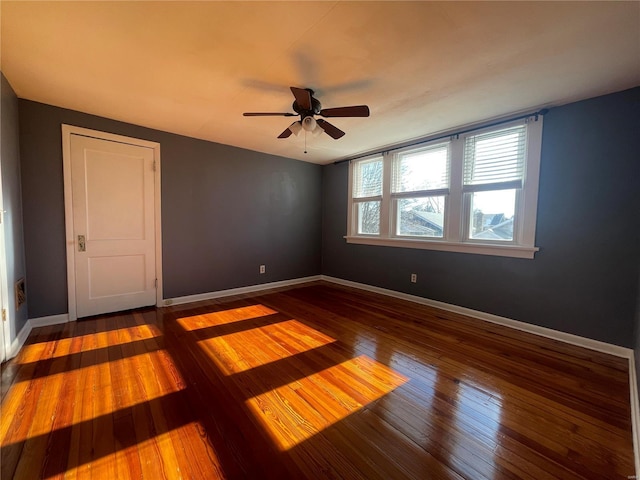 spare room featuring dark hardwood / wood-style flooring and ceiling fan