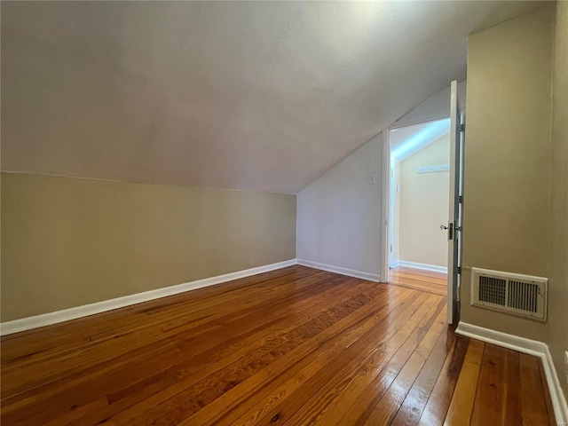 additional living space featuring hardwood / wood-style floors and vaulted ceiling