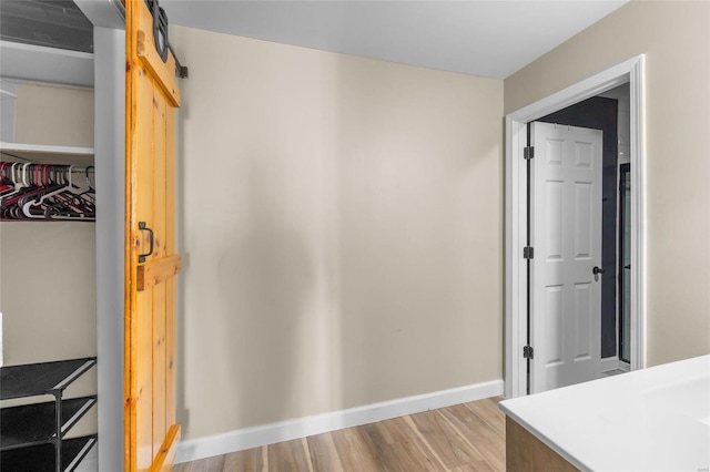 interior space featuring light wood-type flooring, a barn door, and a closet