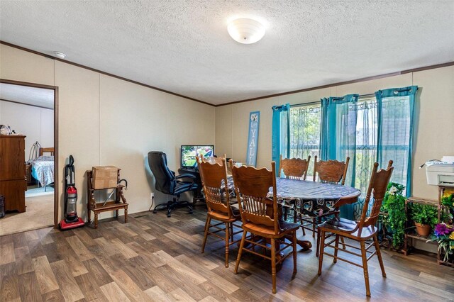 dining area featuring ornamental molding, a textured ceiling, and wood-type flooring