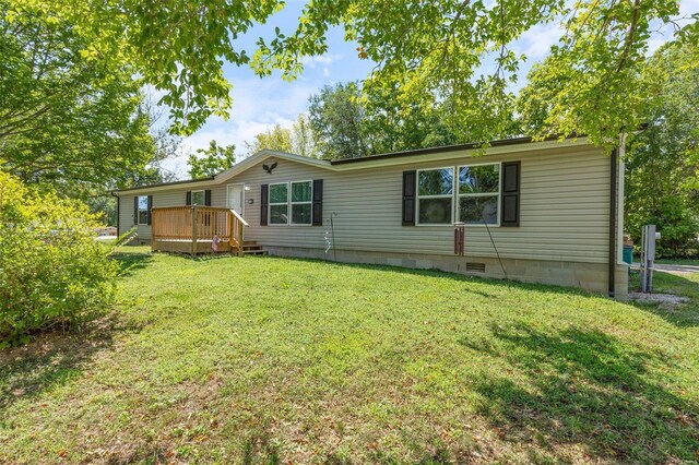 rear view of property with a deck and a yard