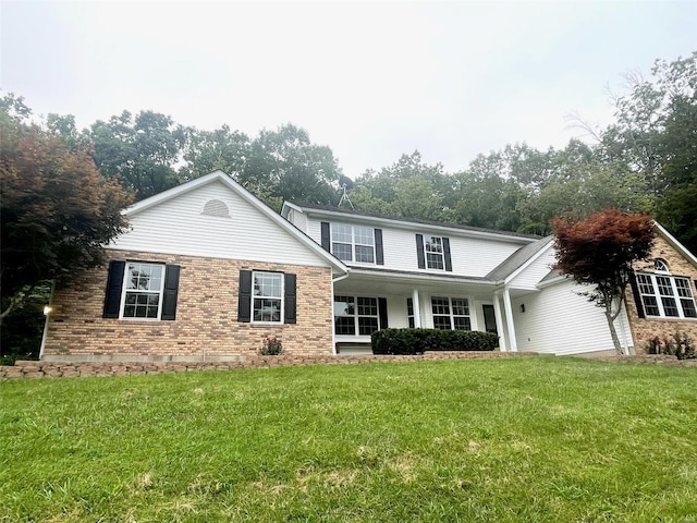 traditional home with brick siding and a front lawn