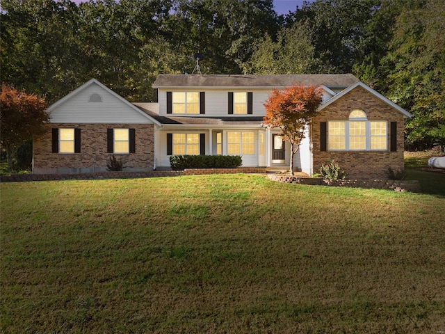 traditional-style home featuring a front lawn and brick siding