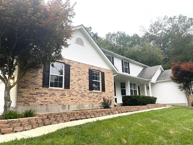 view of front of house with a front lawn and brick siding