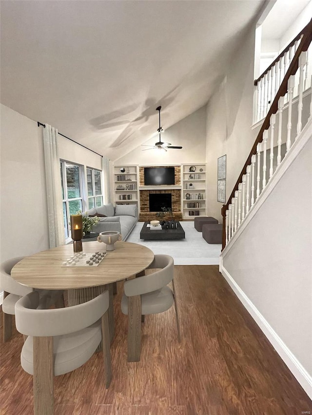 dining space with a fireplace, hardwood / wood-style floors, ceiling fan, lofted ceiling, and built in shelves