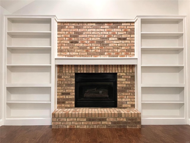 room details featuring a fireplace, wood-type flooring, and built in features