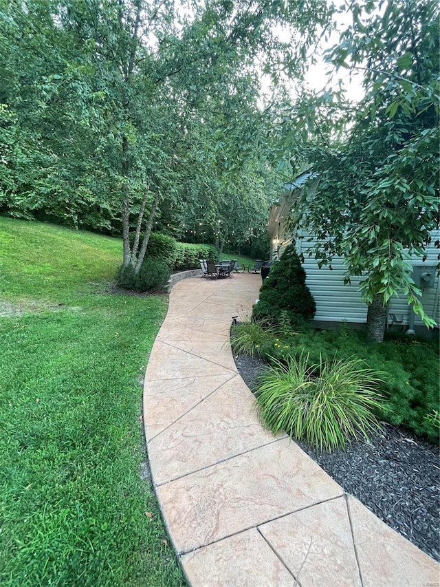 view of home's community featuring a patio and a lawn