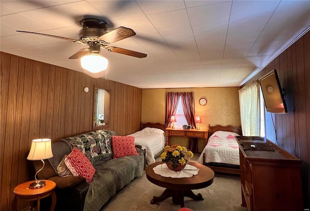 carpeted living room with plenty of natural light, ceiling fan, and wooden walls