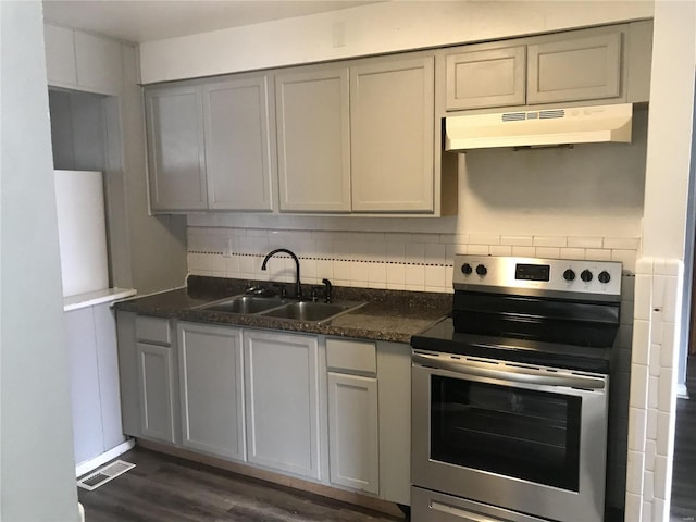 kitchen featuring under cabinet range hood, backsplash, visible vents, a sink, and stainless steel electric range oven