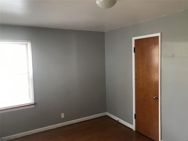 empty room featuring dark wood finished floors and baseboards