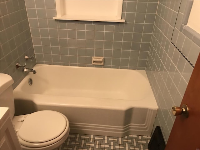 bathroom featuring tile walls, vanity, toilet, and tile patterned floors