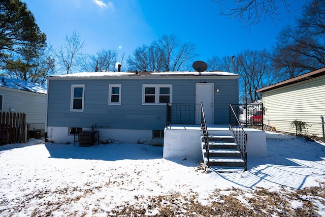 snow covered property with central AC unit