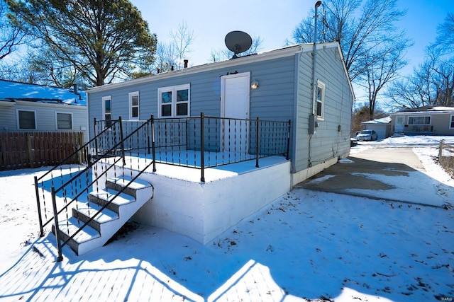 snow covered house featuring a patio