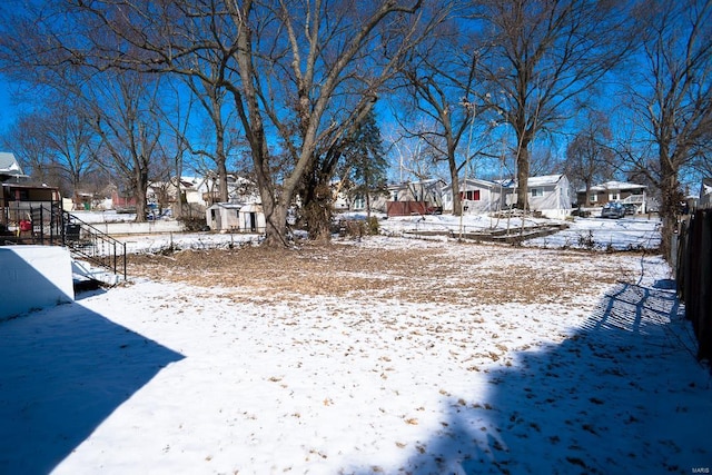 yard layered in snow featuring a residential view