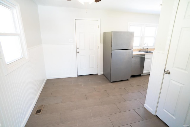 kitchen with dishwasher, sink, refrigerator, white cabinetry, and ceiling fan