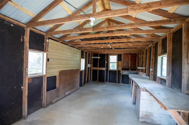 misc room with lofted ceiling with beams and concrete flooring