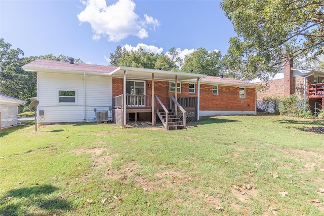 back of property with a deck and a yard