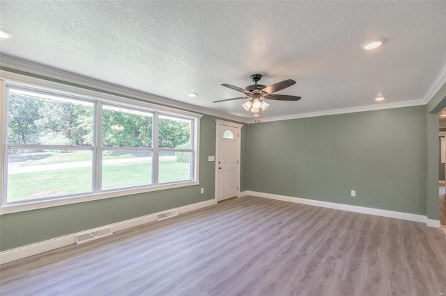 unfurnished room with ceiling fan, a textured ceiling, crown molding, and light hardwood / wood-style floors