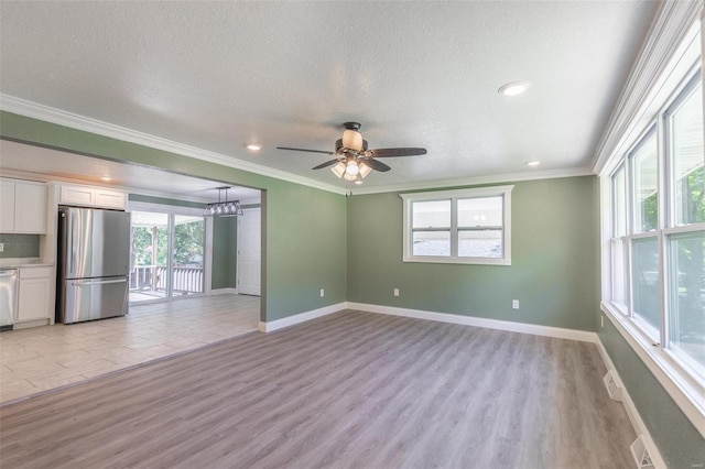 unfurnished living room with light wood-type flooring, a textured ceiling, ornamental molding, and ceiling fan