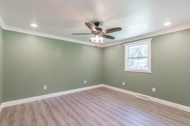 empty room with ceiling fan, a textured ceiling, light hardwood / wood-style flooring, and ornamental molding