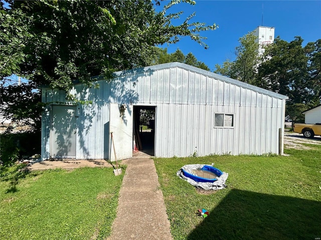 view of outbuilding featuring a yard and an outdoor fire pit