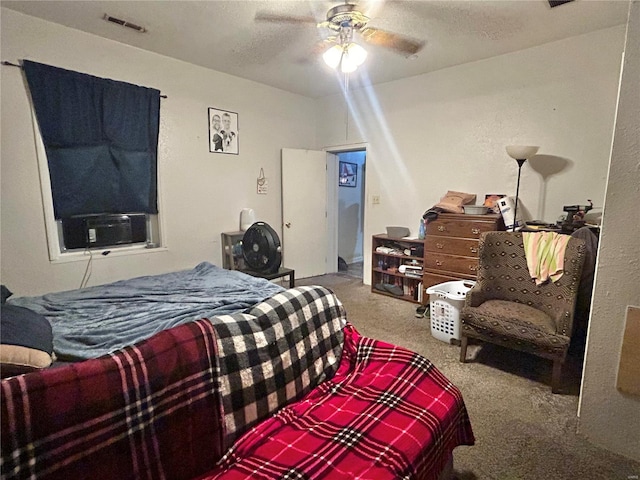 bedroom with a textured ceiling, ceiling fan, and carpet