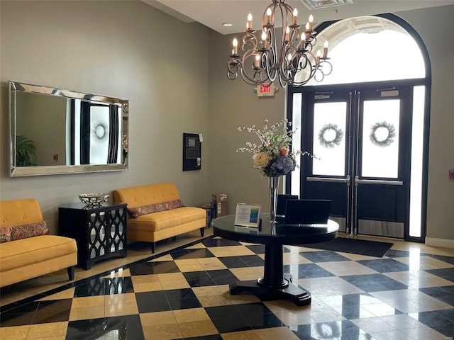 tiled foyer entrance with a notable chandelier and a high ceiling