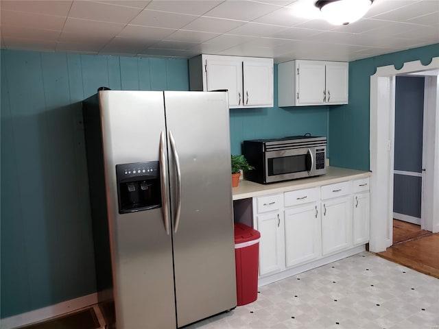 kitchen with stainless steel appliances, white cabinets, and light hardwood / wood-style flooring