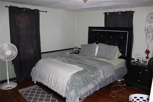 bedroom with a textured ceiling and hardwood / wood-style floors