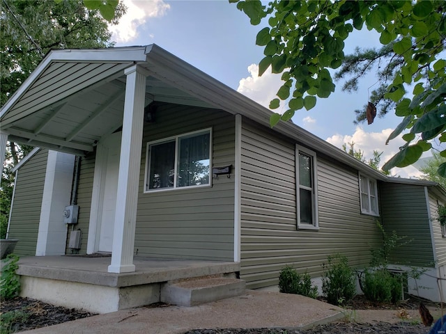 view of side of property featuring covered porch