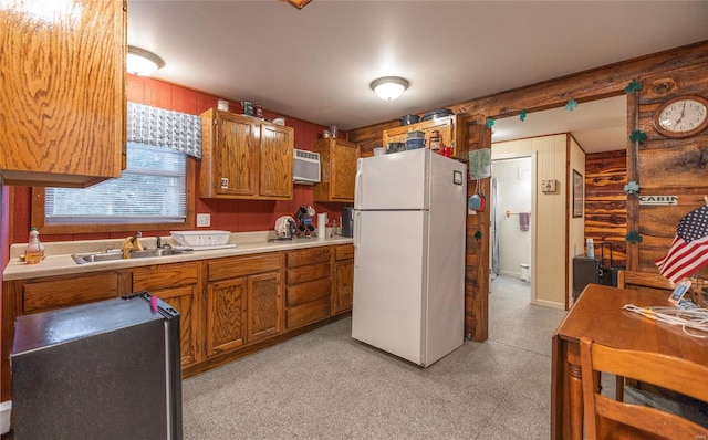 kitchen with sink, white refrigerator, and a wall mounted air conditioner