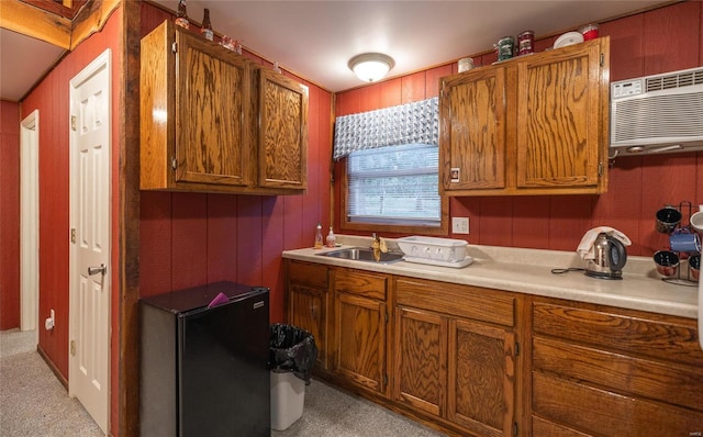 kitchen with sink, light carpet, and a wall unit AC