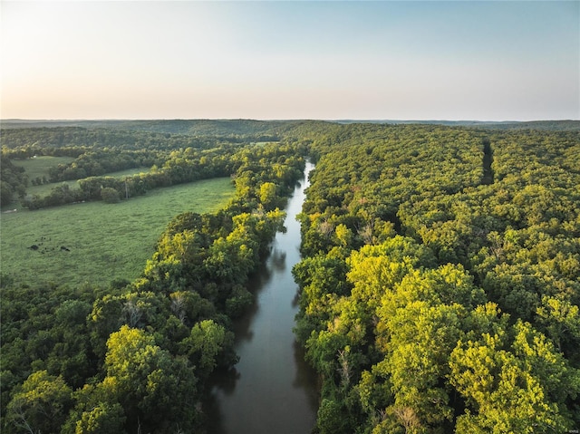 aerial view at dusk featuring a water view