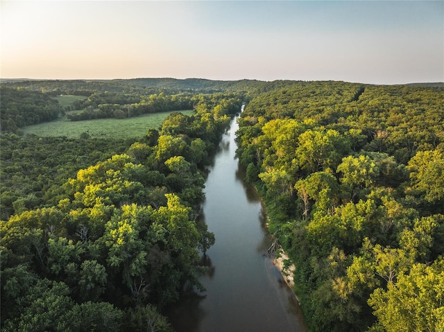 aerial view at dusk featuring a water view