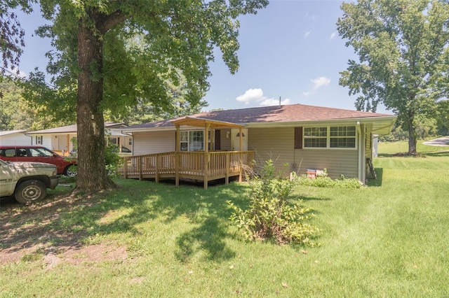 back of property featuring a lawn and a deck