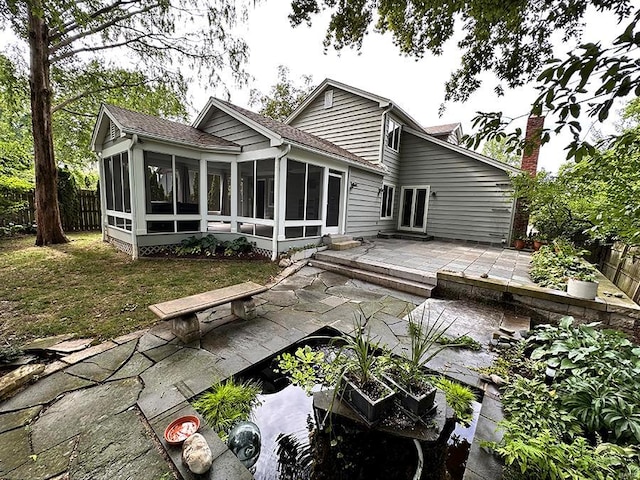 rear view of house featuring a sunroom and a patio