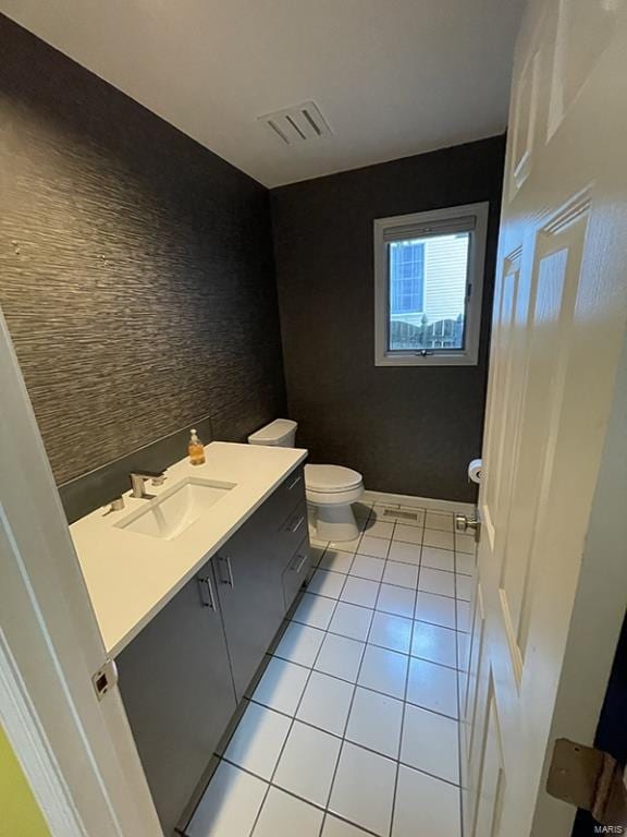 bathroom with tile patterned flooring, vanity, and toilet