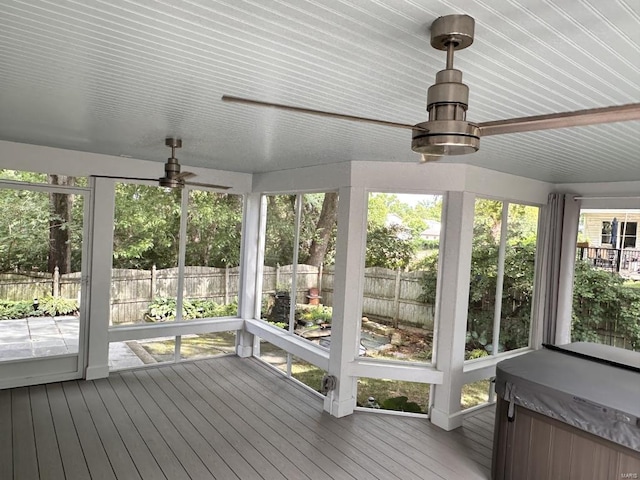 unfurnished sunroom featuring ceiling fan