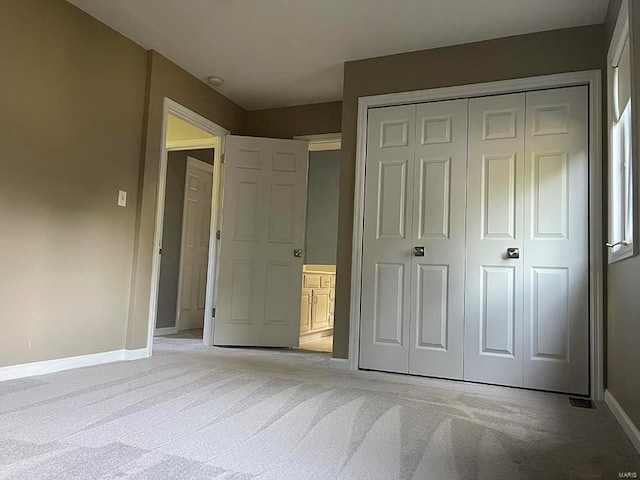 unfurnished bedroom with light colored carpet and a closet