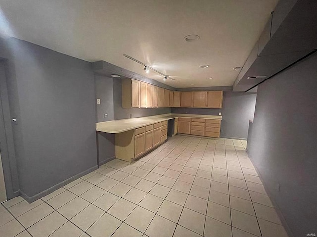 kitchen featuring light brown cabinets, light tile patterned flooring, and rail lighting