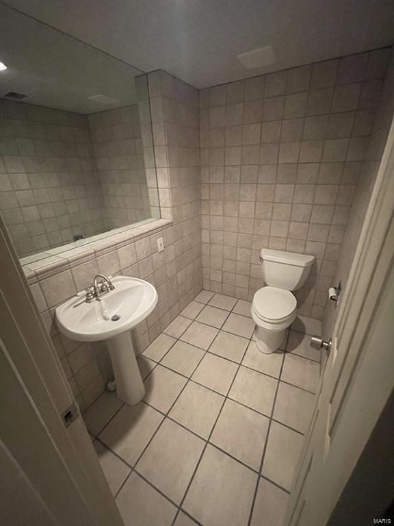 bathroom featuring tile walls, tasteful backsplash, tile patterned floors, and toilet