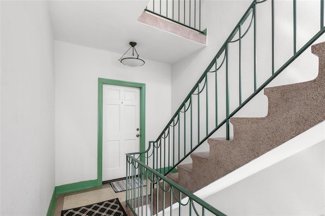 entrance foyer featuring stairs and baseboards