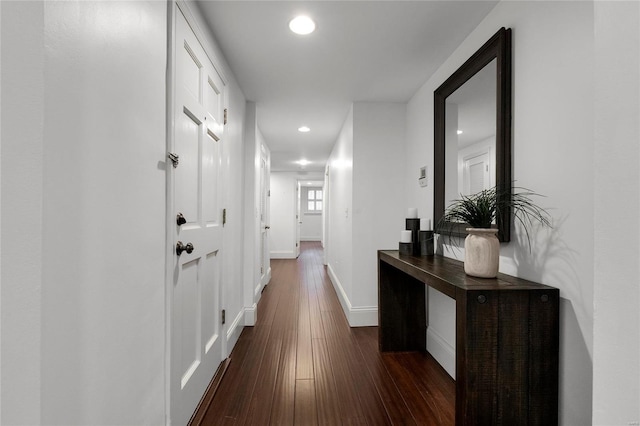 corridor featuring baseboards, dark wood-type flooring, and recessed lighting