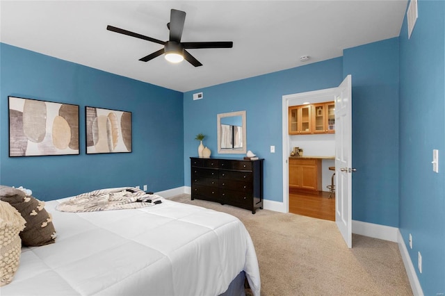 bedroom with a ceiling fan, light colored carpet, visible vents, and baseboards